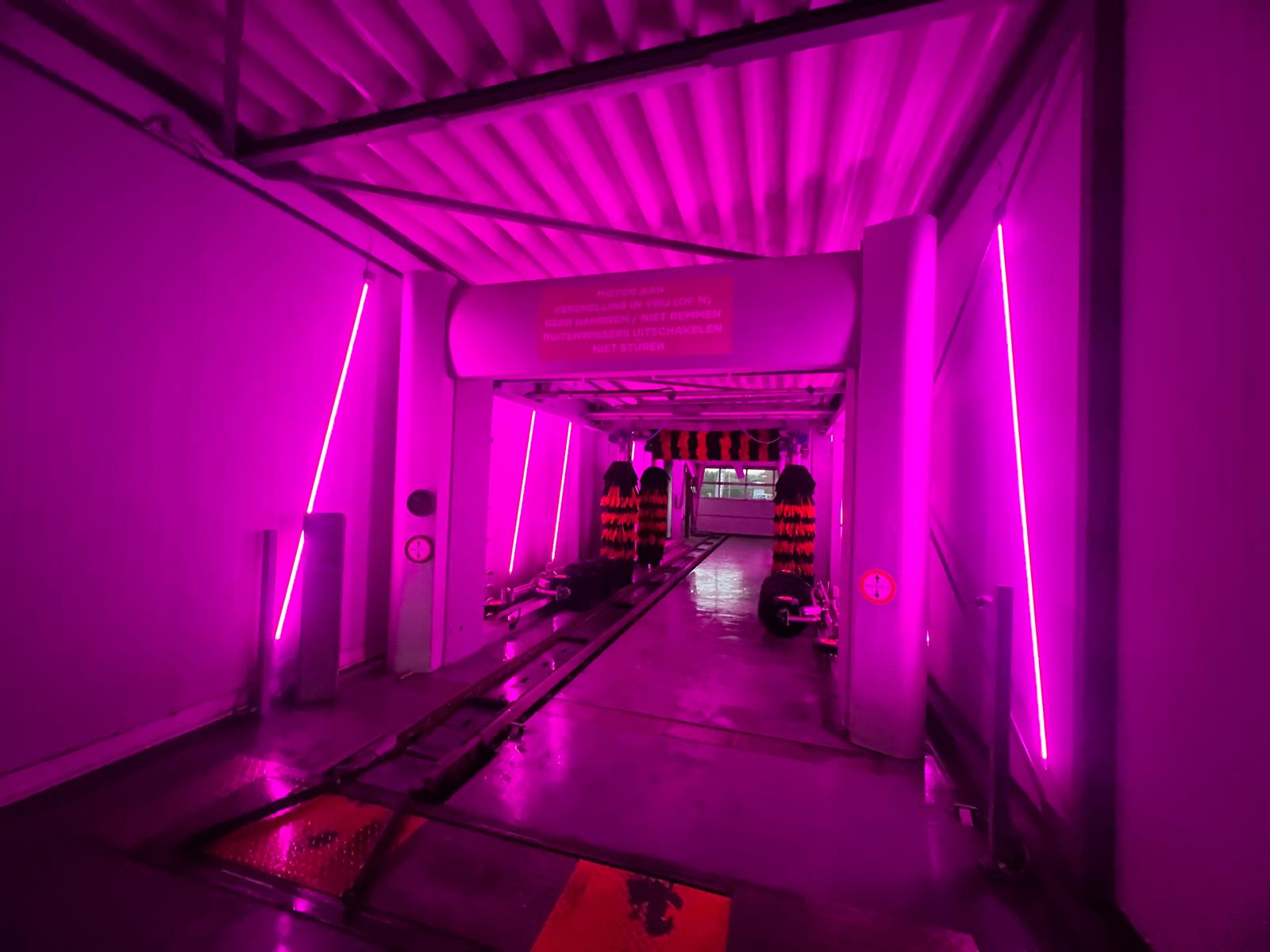 Eindresultaat van de roze maatwerkverlichting in de wasstraat vanuit een derde hoek